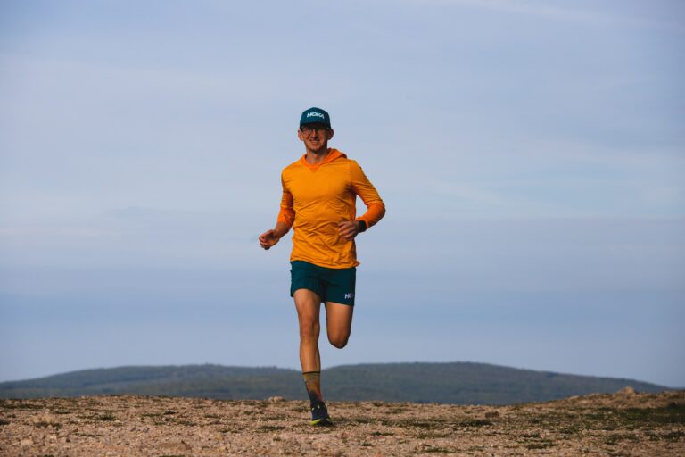 Patrik Milata, founder of Running Camps, running forward with a beautiful landscape in the background.