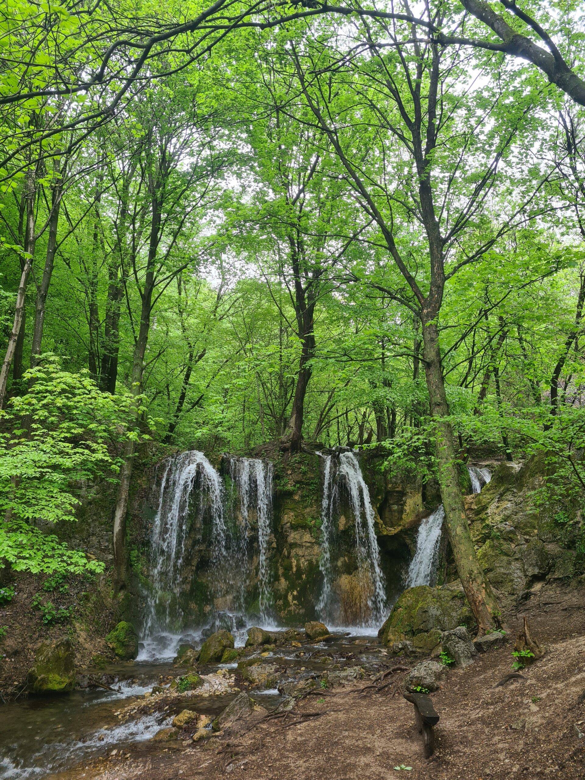 Summer image in natural surroundings featuring a cascading waterfall.